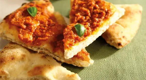 Tranches de pizza basilic, garnies d'une sauce rouge savoureuse et d'une feuille de basilic frais.