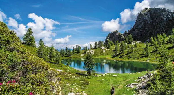 Sentiero panoramico nella Valle Maira, cosa vedere: un lago alpino specchiato, rocce imponenti e sentieri verdi.