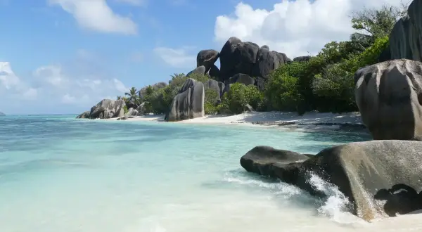 Rajska plaża na Seszelach z turkusową wodą, białym piaskiem i charakterystycznymi granitowymi skałami. Idealne miejsce na wycieczkę.