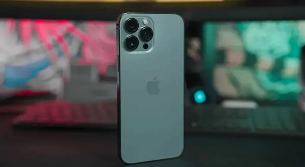 Un iPhone 13 bleu céleste, avec son logo Apple et son triple appareil photo, prêt pour sa date de sortie.