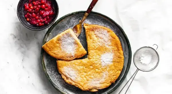 Puszysty omlet z airfryer, posypany cukrem pudrem, podany z żurawiną. Idealny na śniadanie.