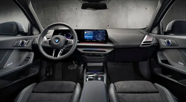 Interiör i en BMW med digital instrumentpanel, stor infotainmentskärm som visar navigation och en ratt med Steptronic-funktion.