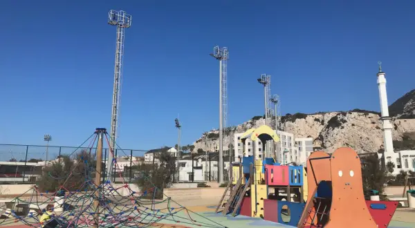 Parque infantil colorido con el Peñón de Gibraltar al fondo. ¡Un lugar ideal que hacer en Gibraltar con niños!