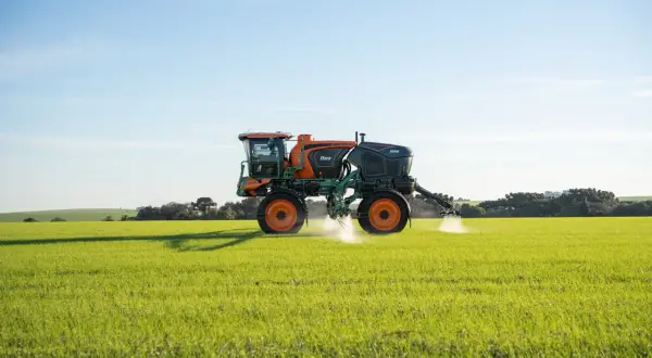 Pulvérisateur agricole Stara 3000 en action, assurant le nettoyage et la protection des cultures dans un champ verdoyant sous un ciel bleu.