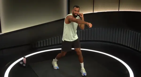 Man in athletic wear throws a powerful cross punch during a workout.