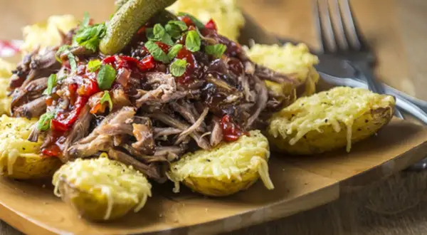 Pulled pork med en härlig sås, serverad med gratinerade potatishalvor och en dillgurka. Perfekt sås till pulled pork!