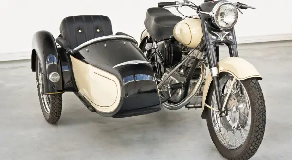 Moto con sidecar clásica, color crema y negro, lista para un paseo nostálgico.