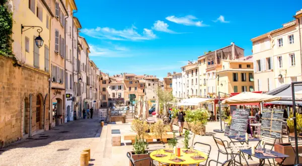 Sonniger Platz in Aix-en-Provence mit Cafés und Geschäften. Entdecken Sie hier die besten Aix-en-Provence Geheimtipps für Ihren Urlaub.