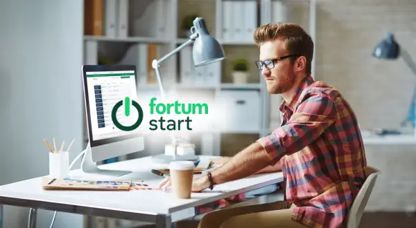 Mężczyzna przy biurku pracuje na komputerze z logo Fortum.