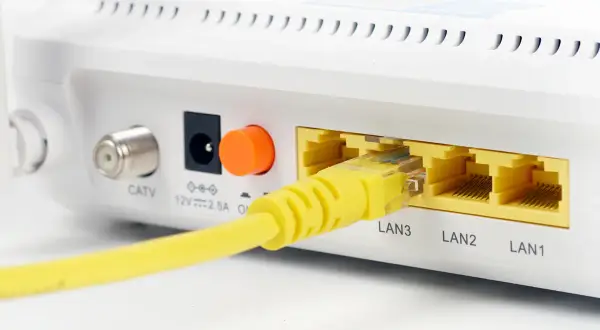Żółty kabel sieciowy podłączony do portu LAN3 routera. Widoczne też złącze CATV i zasilania.