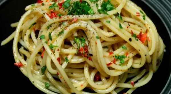 Pyszne spaghetti aglio olio, posypane natką pietruszki i płatkami chili. Idealny przepis na szybki obiad.