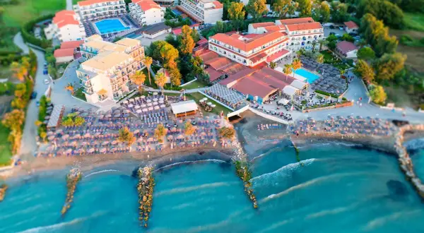 Widok z lotu ptaka na hotel z basenem i plażą pełną leżaków i parasoli. Idealne miejsce na wakacje, jak z marzeń, niczym z katalogu Itaka.