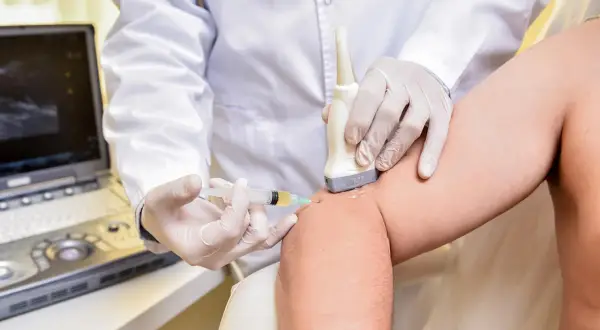 Médecin guidant une échographie pour une infiltration. L'effet de l'infiltration au bout de combien de temps est une question courante.