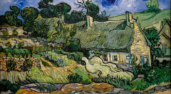 Ein Dorf mit strohgedeckten Häusern und üppiger Vegetation, typisch für die Werke van Goghs. Der Himmel ist dramatisch blau mit wirbelnden Wolken.