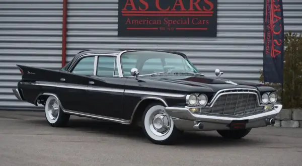 Svart de Soto bil med kromdetaljer och vita däcksidor framför AS CARS. En klassisk amerikansk dröm.