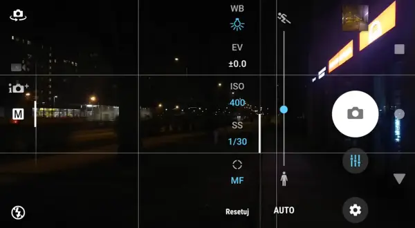 Ekran telefonu z widokiem nocnym. Ustawienia aparatu pokazują, jak ustawić długie naświetlanie, z widocznym ISO 400 i czasem 1/30s.