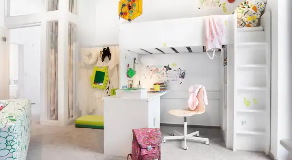 Ein kleines Kinderzimmer, perfekt eingerichtet für ein Schulkind. Ein Hochbett, Schreibtisch und viel Platz zum Spielen und Lernen.
