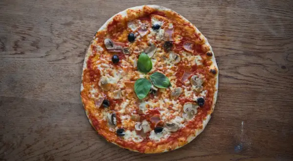 Pyszna pizza rzymska z pieczarkami, szynką i oliwkami, idealna na wieczór z bliskimi. Ten przepis na pizzę rzymską jest prosty i szybki.