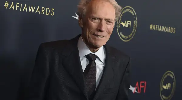 Clint Eastwood w garniturze na tle napisu #AFIawards.