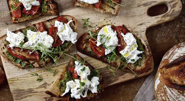 Grillade bruschetta med krämig ost, soltorkade tomater och pesto. En härlig ostupplevelse!