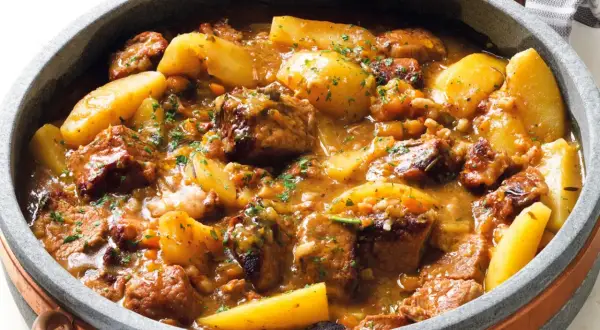Un invitante spezzatino di manzo morbidissimo con patate, cotto lentamente in un ricco sugo e guarnito con prezzemolo fresco.