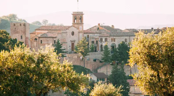 Borgo antico di San Ginesio, con la sua torre e la chiesa, immerso nel verde. Un paesaggio maturo, come un frutto pronto da gustare.