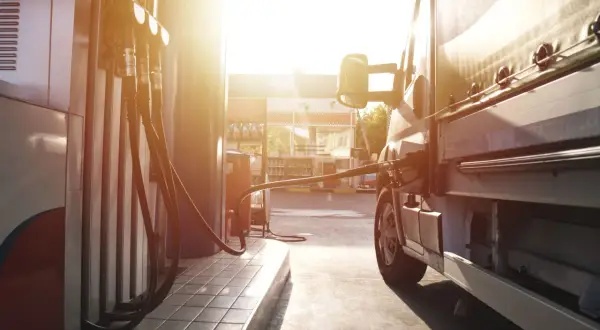 Lastenbilen tankas med diesel i solnedgången. En gammal dieselmotor behöver sin energi.