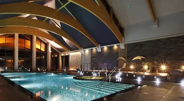Luksusowe hotele na Mazurach z basenem oferują relaks w nowoczesnym stylu. Wnętrze basenu z podświetlanymi schodkami i jacuzzi.