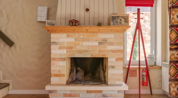 Ein Kamin aus Sandstein, der gereinigt wurde, mit Holzverkleidung und Dekorationen.