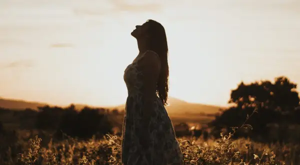 Kobieta w letniej sukience wpatruje się w niebo, szukając odpowiedzi. Jak odróżnić natchnienie boże od własnych projekcji psychicznych?