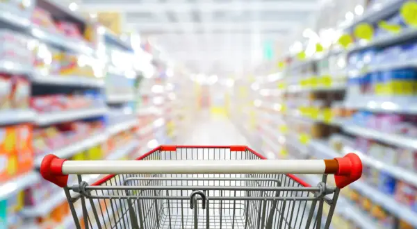 Wózek sklepowy w alejkach pełnych produktów. Z aplikacją blix zakupy stają się prostsze i szybsze.