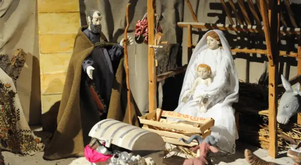 Krippenszene mit Maria, Josef und Jesuskind. Die Szene erinnert an die Ursprünge von Weihnachten.