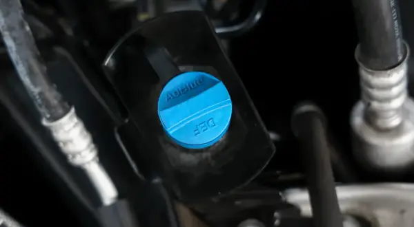 Niebieska nakrętka z napisem AdBlue i DEF, wskazująca na zbiornik płynu AdBlue co to jest, kluczowy dla nowoczesnych diesli.