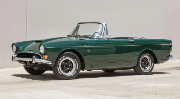 En grön Sunbeam Tiger cabriolet, en klassisk sportbil, står parkerad.
