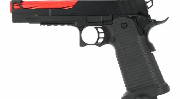 Pistola negra con cañón rojo, lista para el vuelo del águila dorada.