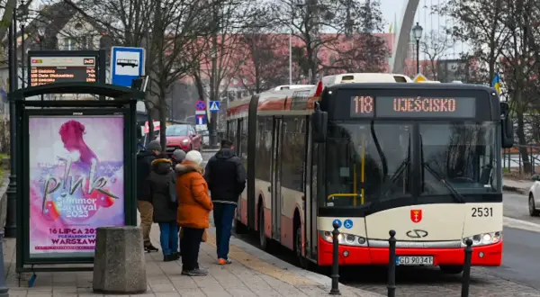 Autobus linii 118 Ujeścisko czeka na przystanku w Gdańsku. Ludzie czekają na zimowy dzień.