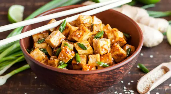 Kawałki tofu w sosie, posypane sezamem i szczypiorkiem, gotowe do podania. Idealna marynata do tofu!