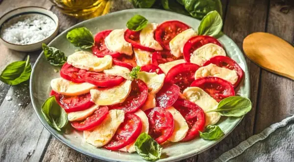 Frische Tomaten und Mozzarella, arrangiert als klassische Caprese. Ein einfaches, aber köstliches Gericht, das die Aromen Italiens feiert.