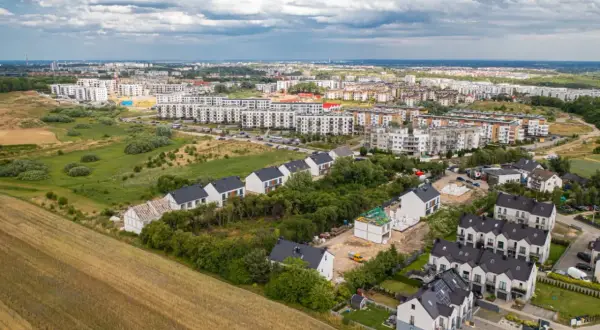 Nowe osiedle domów i bloków mieszkalnych, bliskość natury i infrastruktury miejskiej. Plusy mieszkania w mieście.