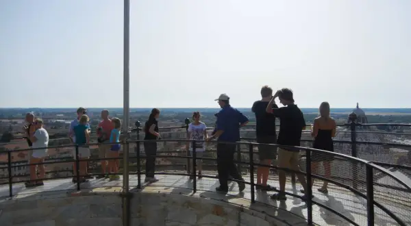 Turisti ammirano il panorama dalla cima, confermando che si può salire sulla Torre di Pisa.