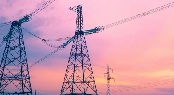 Wieże energetyczne na tle różowego nieba. To jak definicja częstotliwości, która opisuje cykliczność zjawisk.