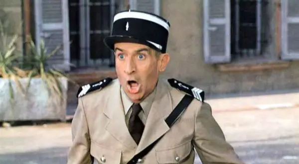 Louis de Funès w filmach, w mundurze żandarma, z miną pełną zdziwienia i rozbawienia.
