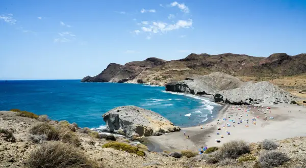 Vista panorámica de las playas de Genoveses y Monsul, con aguas turquesas, arena dorada y formaciones rocosas.