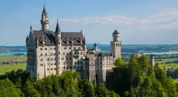 Schloss Neuschwanstein, ett sagoslott i Bayern, reser sig majestätiskt över en grönskande skog.