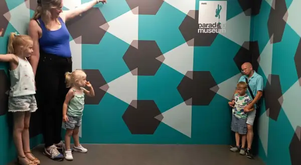 Famille explorant le Paradox Museum Paris, un lieu d'illusions optiques. Avis : une expérience amusante pour tous les âges.