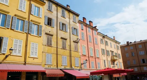 Färgglada hus med persienner i Emilia-Romagna. En solig dag på en italiensk piazza.