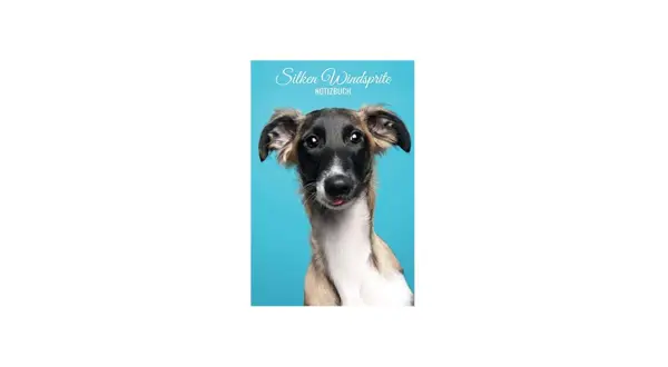 Un gracioso silken windsprite con la lengua afuera, posando para un cuaderno azul.