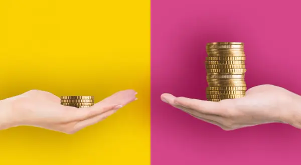 Zwei Hände halten Münzstapel. Eine Hand hat wenig, die andere viel. Zeitarbeit: kein Einsatz, kein Geld.