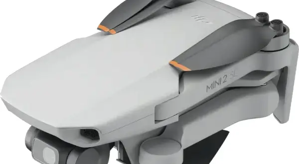 Składany dron DJI Mini 2 SE z kamerą i pomarańczowymi akcentami na śmigłach. Idealny do nauki trików w powietrzu.