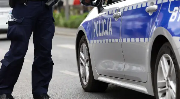 Policjant stoi obok radiowozu. Czy policja może namierzyć wyłączony telefon? To pytanie, na które odpowiedź może być kluczowa w śledztwie.